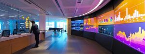 a sleek, modern office space features a large digital screen displaying intricate seo analytics graphs and vibrant charts, with a focused business professional analysing data on a laptop, illuminated by soft, ambient lighting.